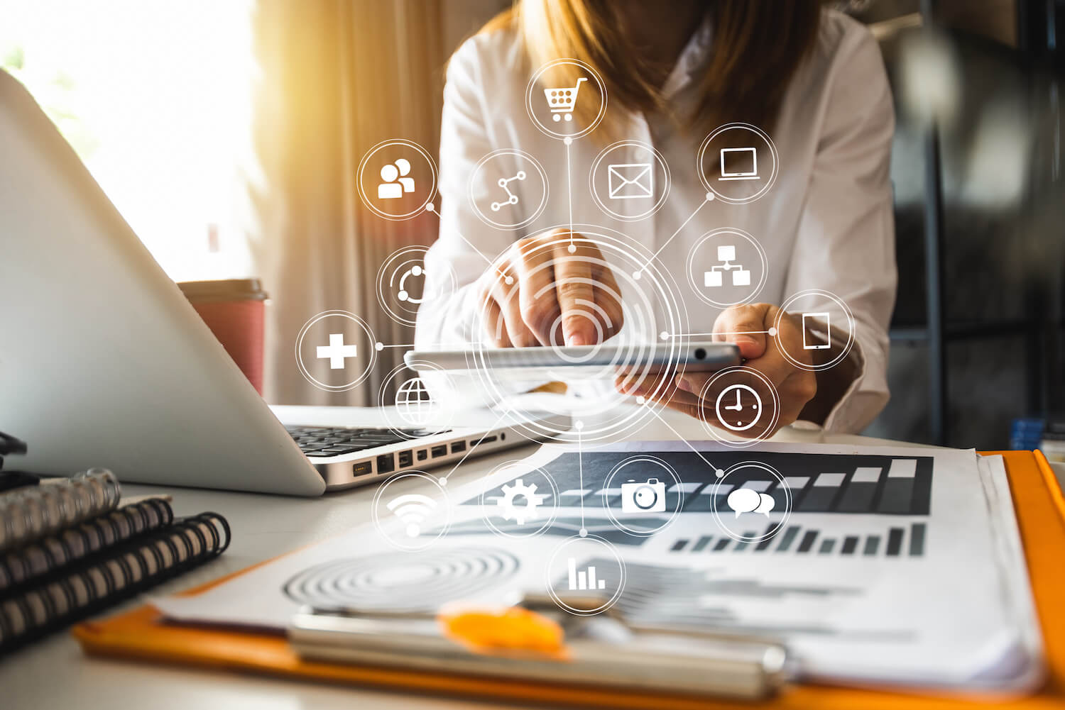 person at desk with computer and digital marketing icons